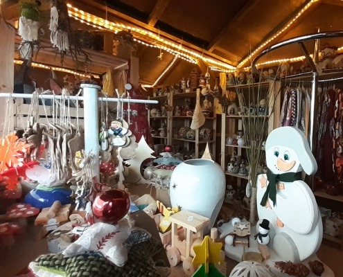 Blick in die weihnachtliche Verkaufshütte mit Keramik- und Holzprodukten.