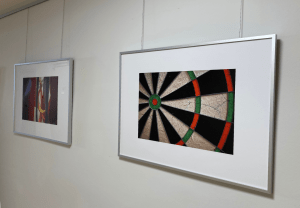 Ein Bilderrahmen an der Wand hängend zeigt einen Ausschnitt einer Dartsscheibe.