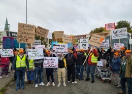Menschen halten Plakate in die Luft.