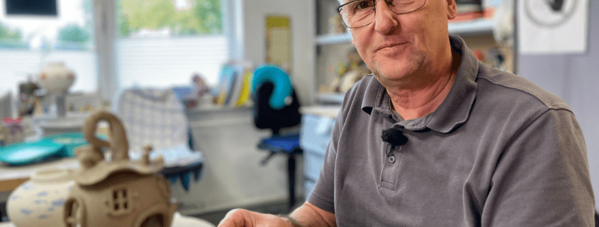 Eine Person formt während des Aktionstages Schichtwechsel in der Keramikwerkstatt der Stralsunder Werkstätten ein Haus aus Ton.