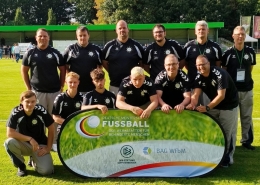 Zwölf Personen, die zur Fußballmannschaft der Stralsunder Werkstätten gehören, stehen auf einem Fußballplatz.